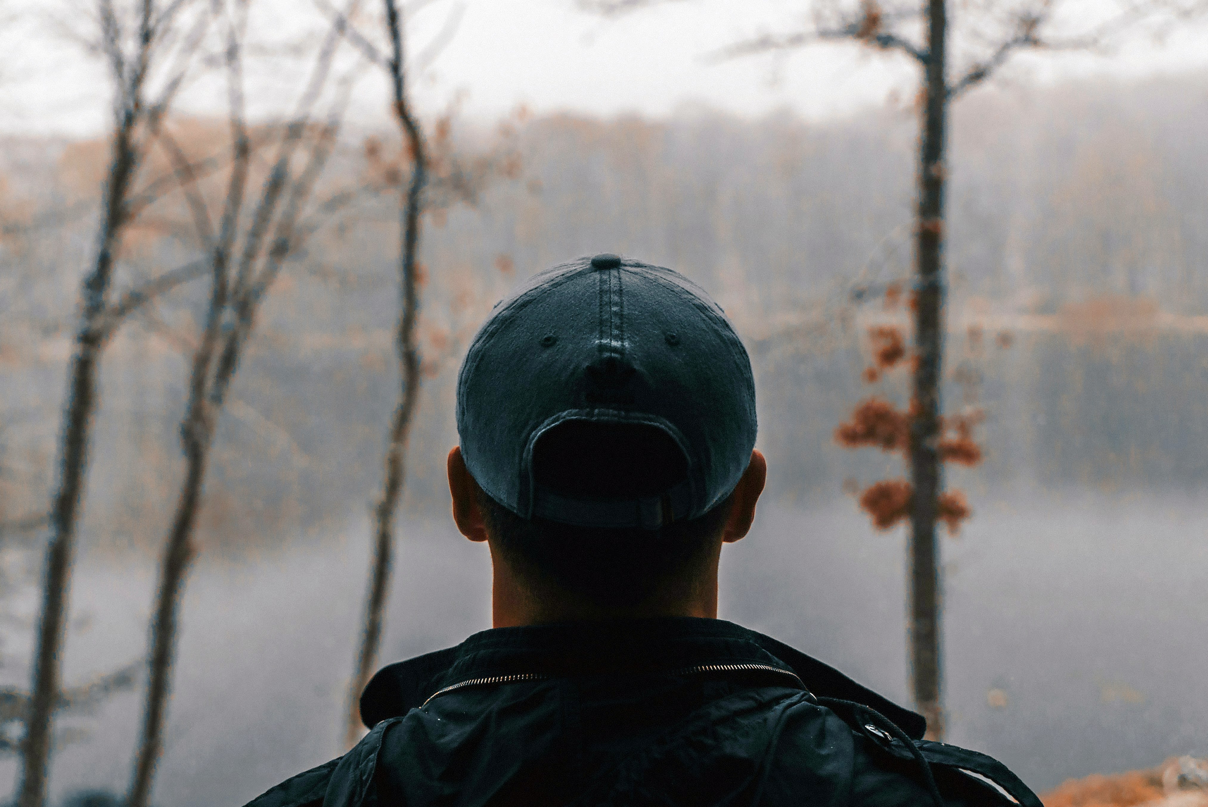 shallow focus photography of man wearing gray baseball cap