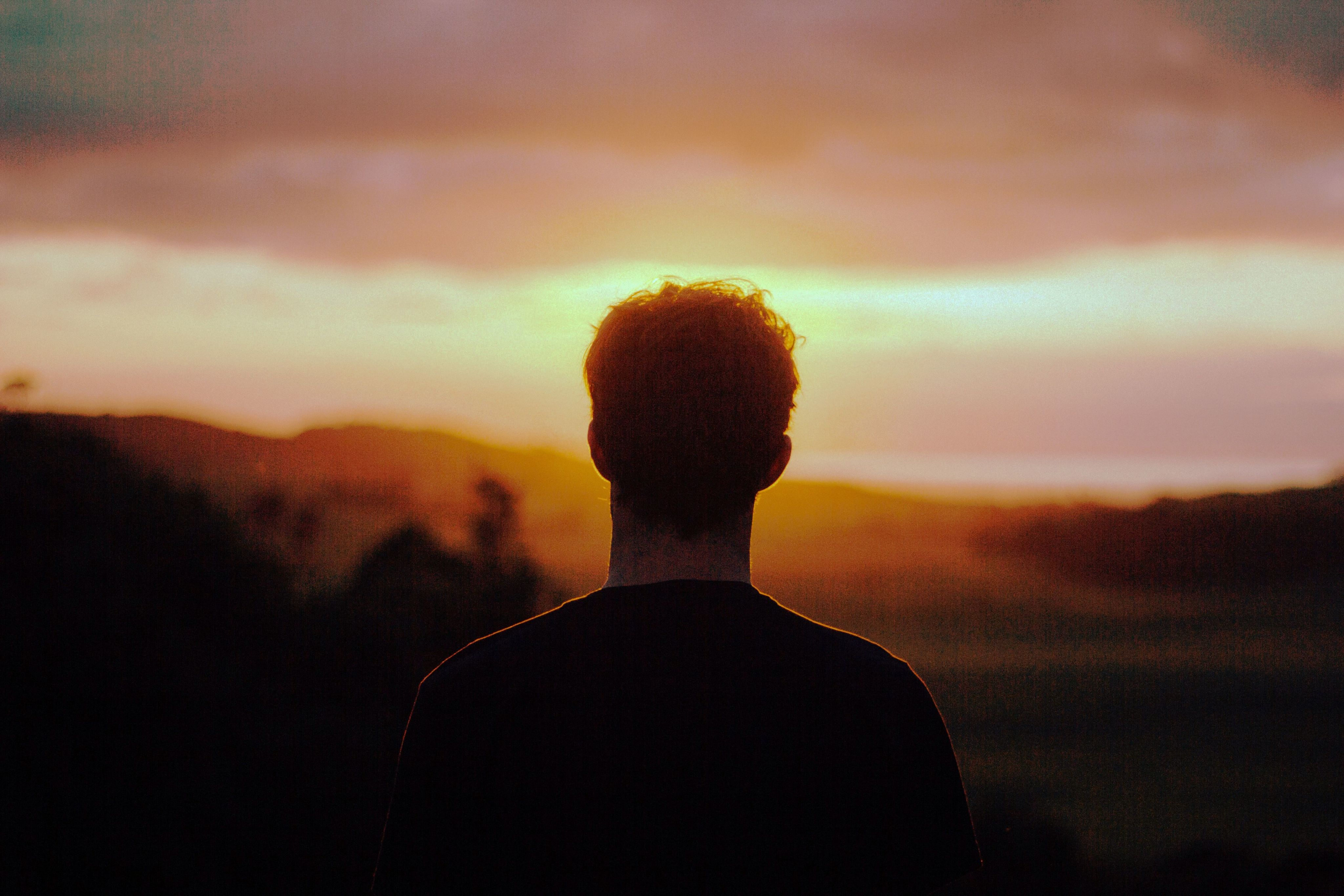 silhouette of a man facing the sunset