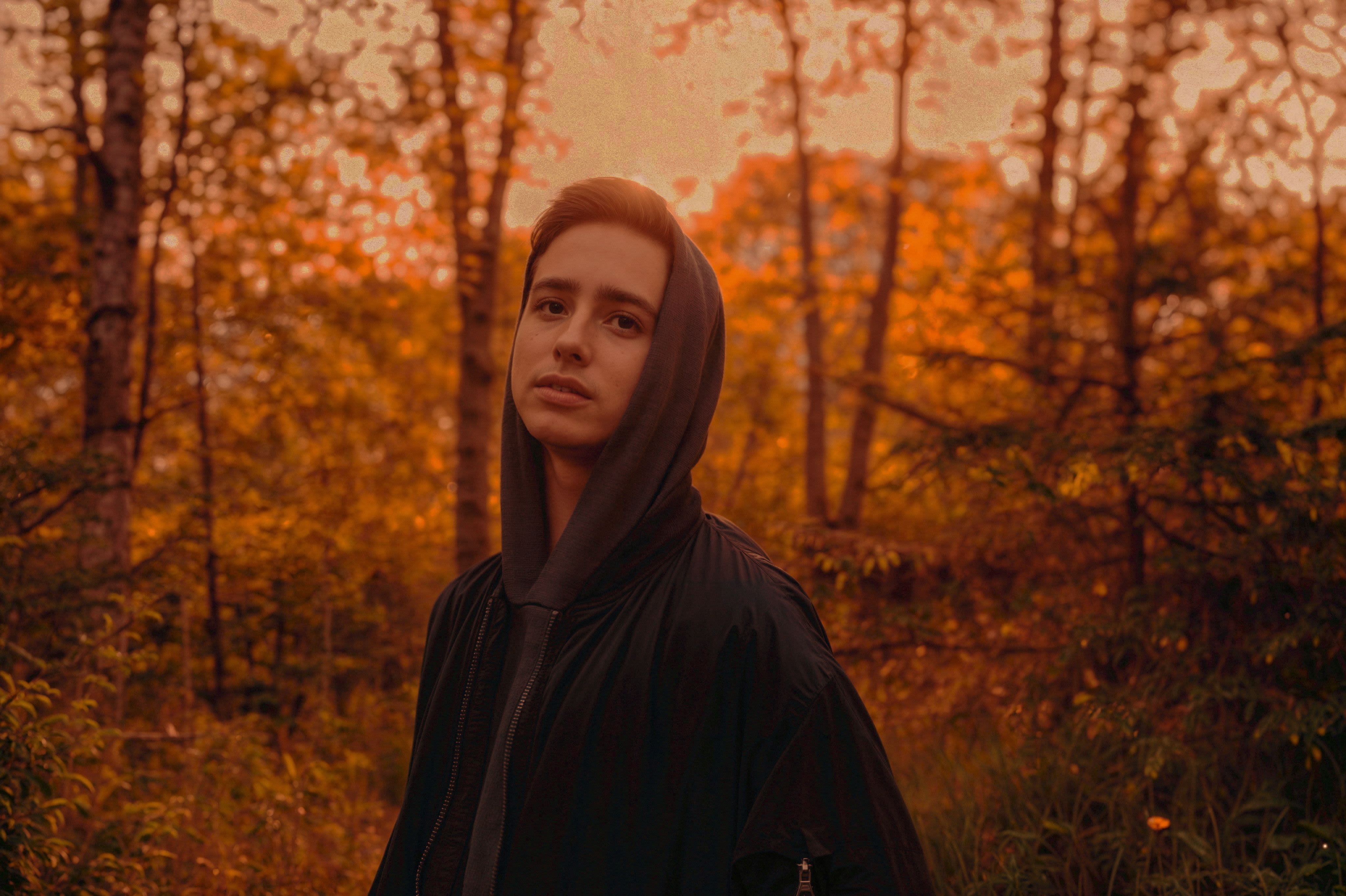 A woman in a hooded jacket standing in a forest