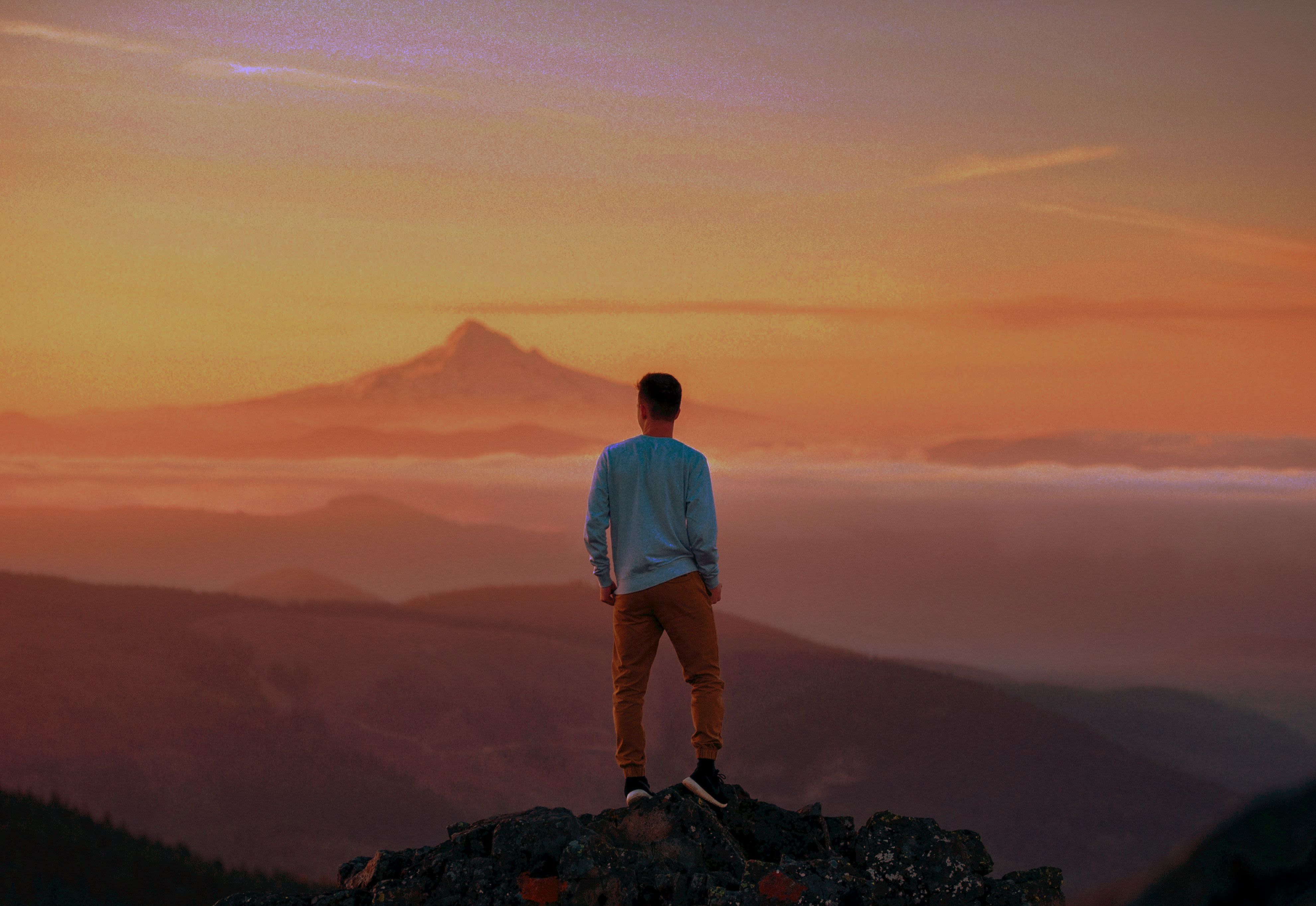 man standing on top of mountain